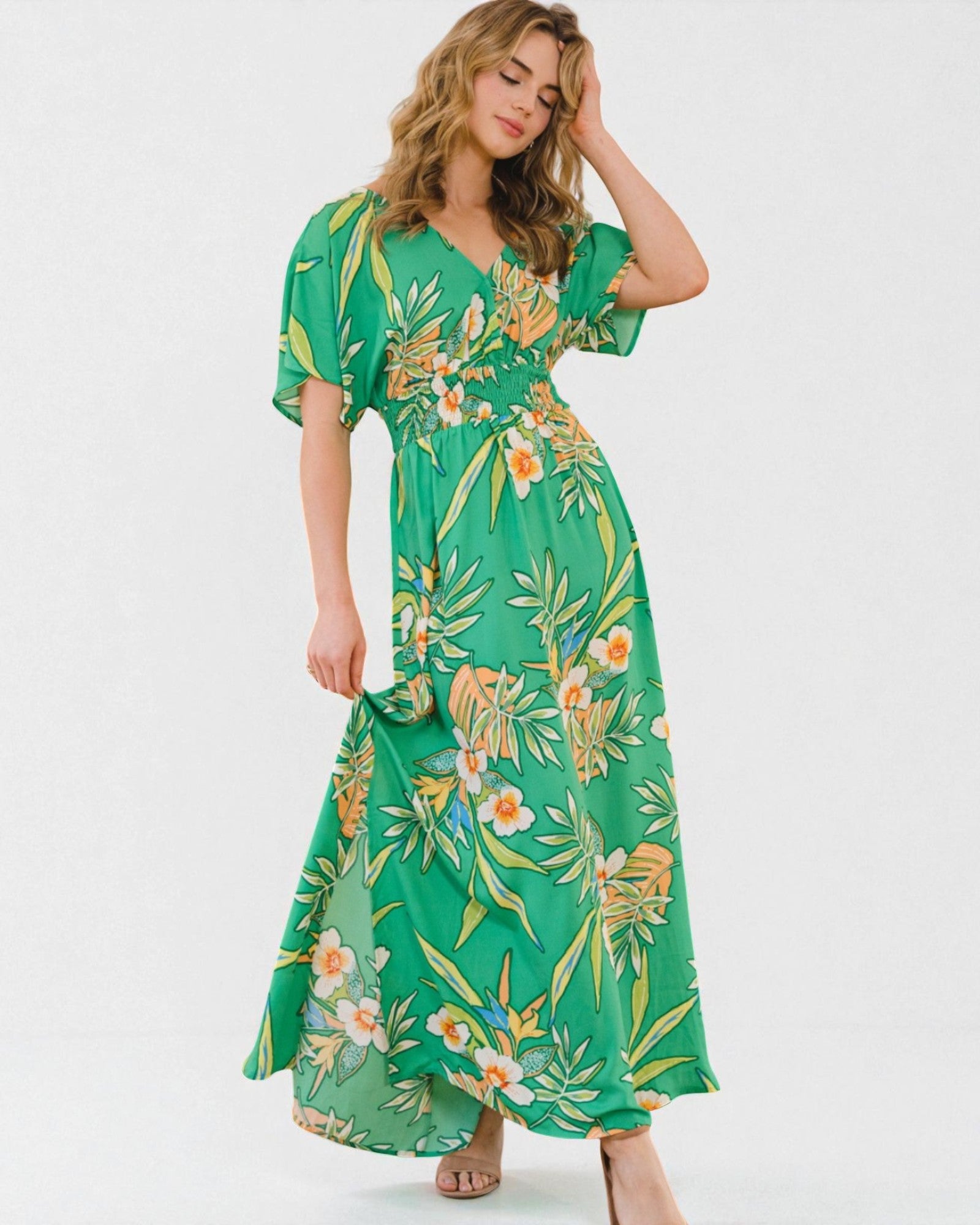 Woman wearing a green floral dress on a white background