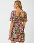 Woman wearing a colorful floral dress on a white background