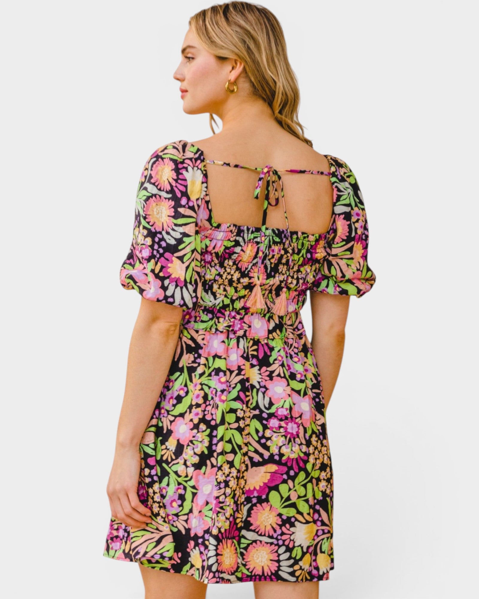 Woman wearing a colorful floral dress on a white background