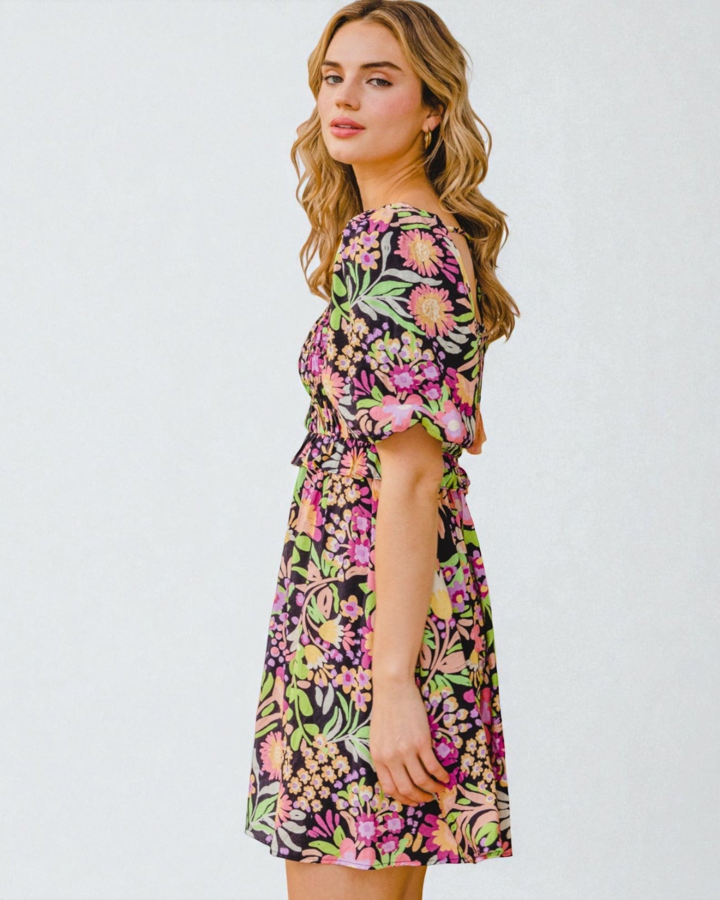 Woman wearing a colorful floral dress on a white background