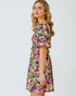 Woman wearing a colorful floral dress on a white background