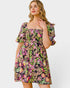 Woman wearing a colorful floral dress on a white background