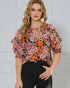 Woman wearing a floral blouse with a plain background