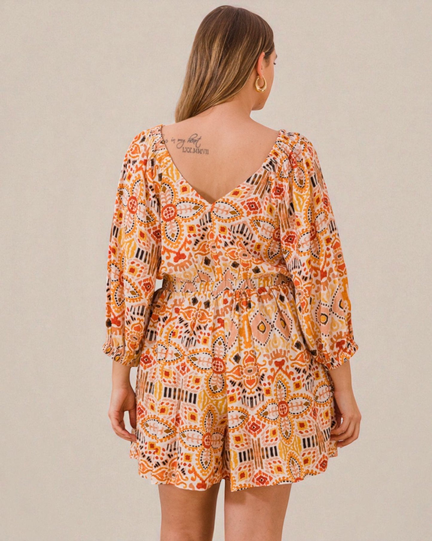 Woman wearing a patterned dress with a beige background