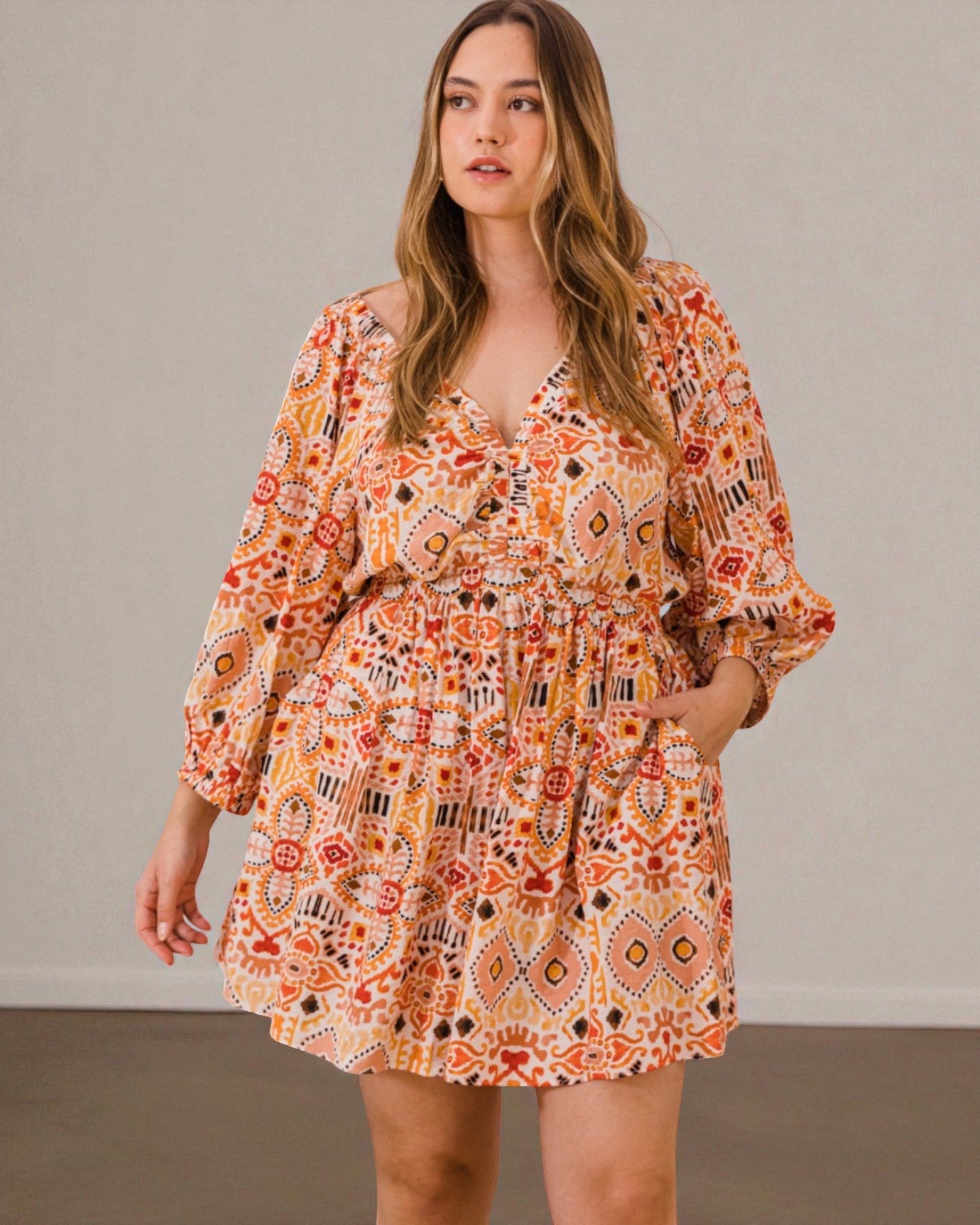 Woman wearing a patterned dress against a plain background