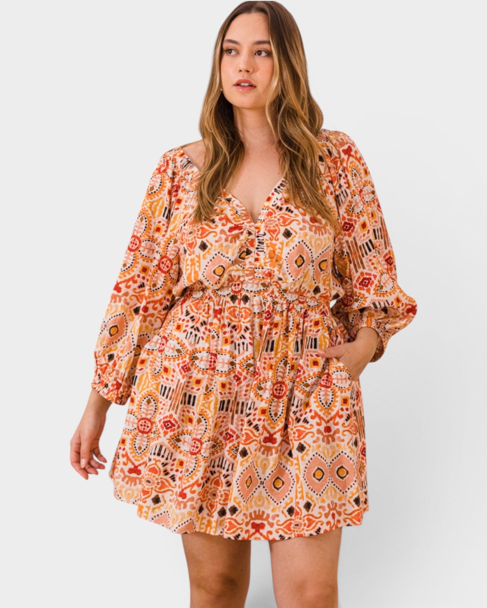 Woman wearing a patterned romper on a plain background