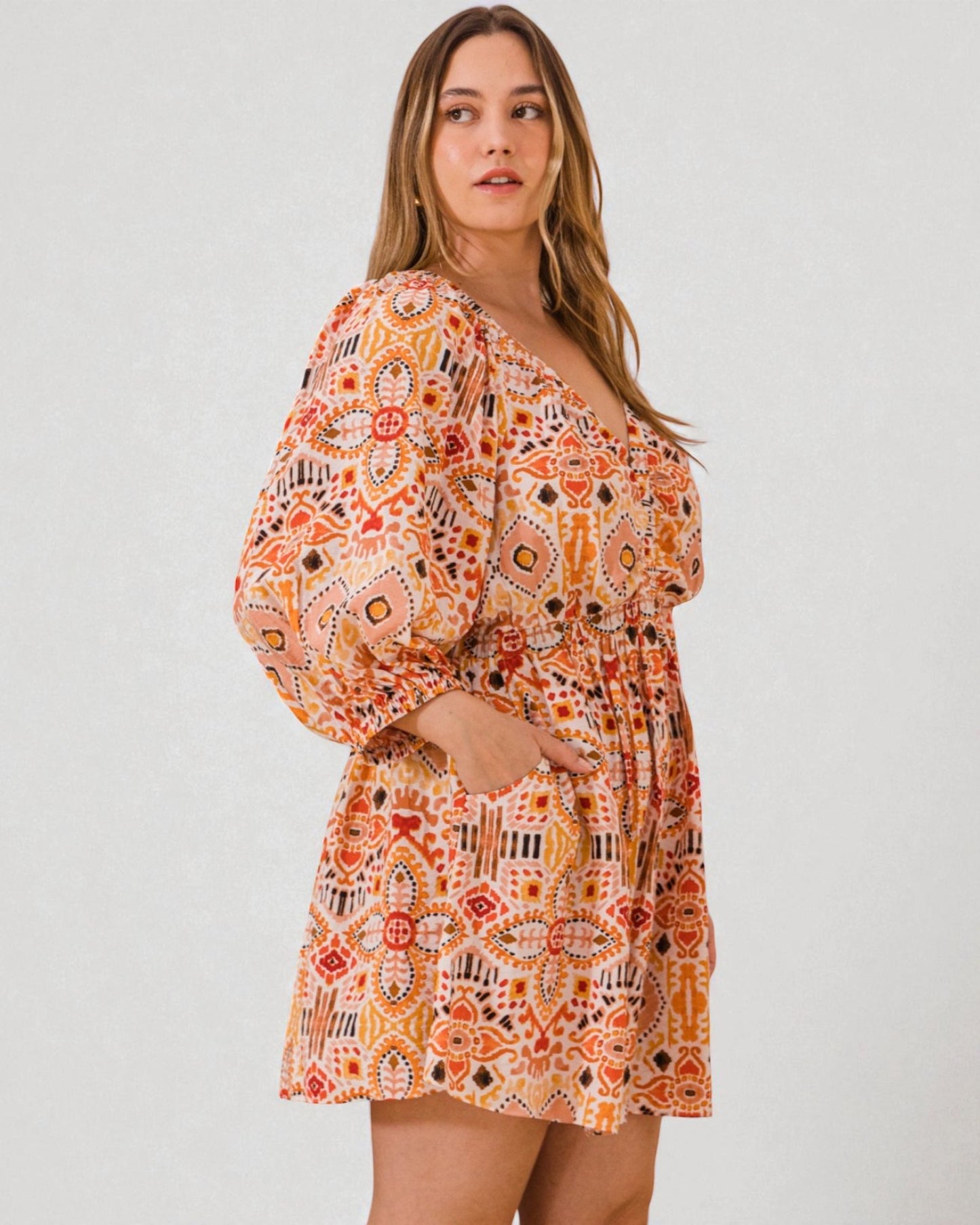 Woman wearing a patterned dress on a plain background