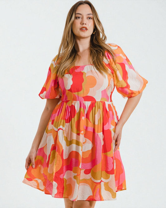 Woman wearing a colorful floral dress on a white background