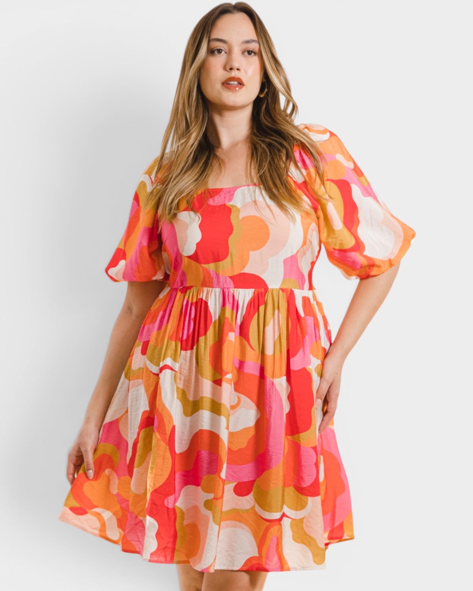 Woman wearing a colorful floral dress on a white background