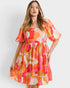 Woman wearing a colorful floral dress on a white background