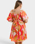 Woman wearing a colorful patterned dress on a white background