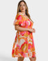 Woman wearing a colorful dress with abstract pattern on a white background