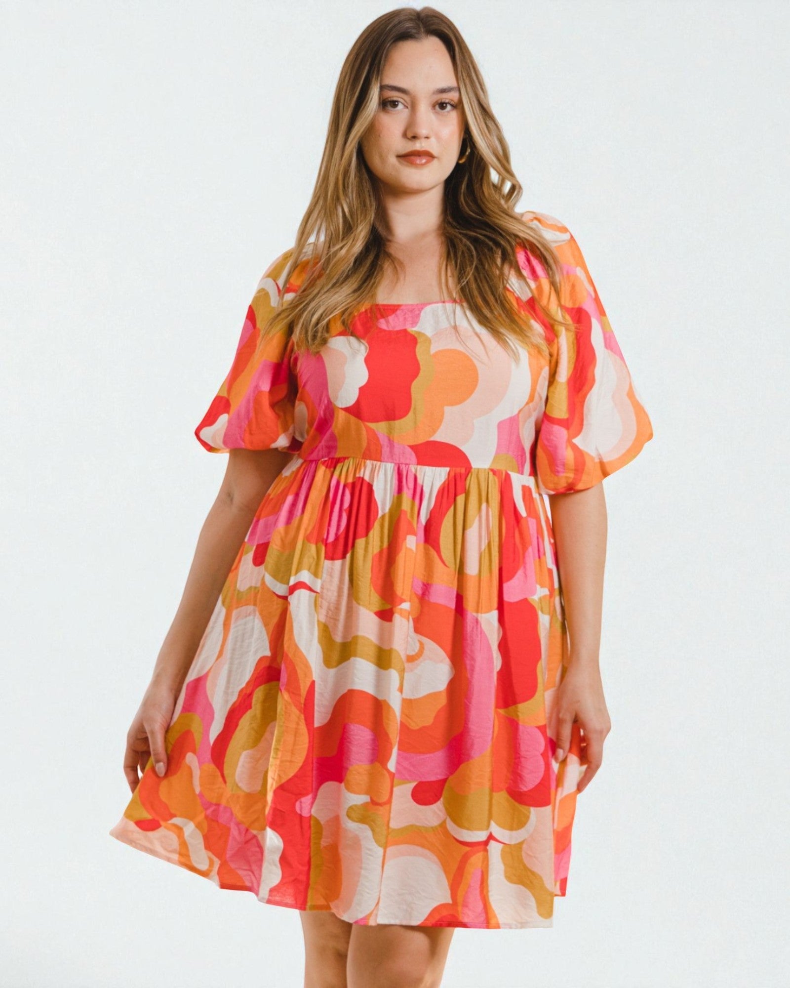 Woman wearing a colorful floral dress on a white background