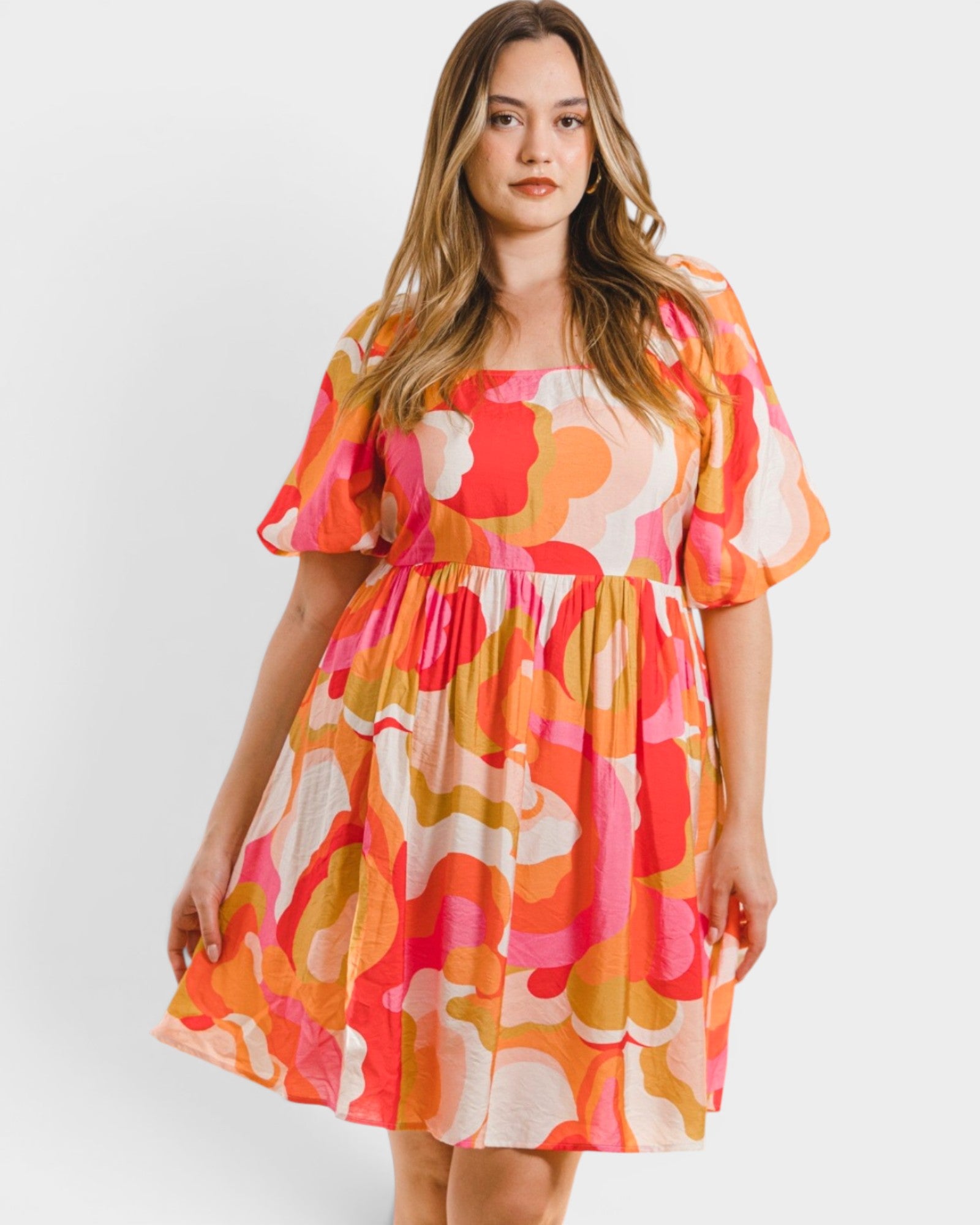 Woman wearing a colorful floral dress on a white background