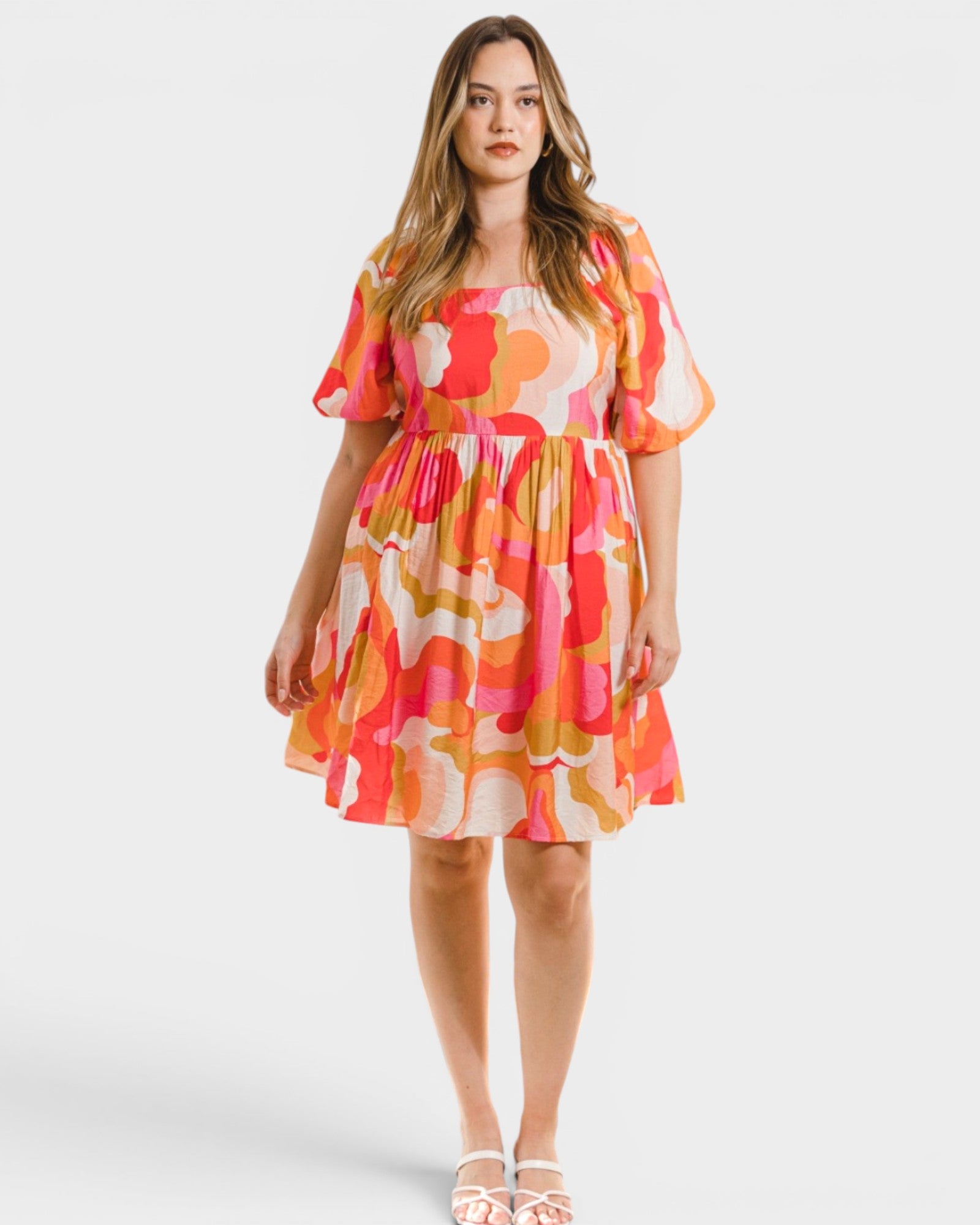 Woman wearing a colorful floral dress on a white background