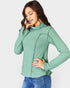Woman wearing a green long-sleeve top against a white background