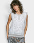 Woman wearing a sleeveless top with lace details on a plain background