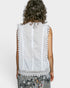 White sleeveless top with lace detailing worn by a person on a white background