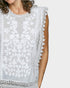 White lace-trimmed top worn by a person on a white background