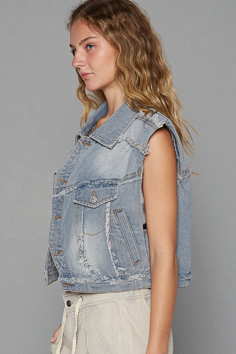 Woman wearing a light blue denim vest against a gray background