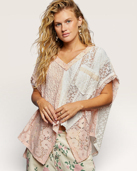 Woman wearing a floral dress and lace cover-up against a white background