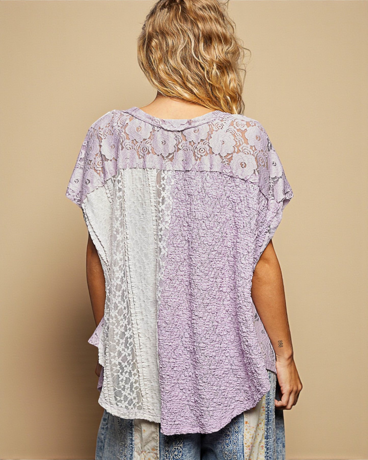 Woman wearing a patterned top with a beige background