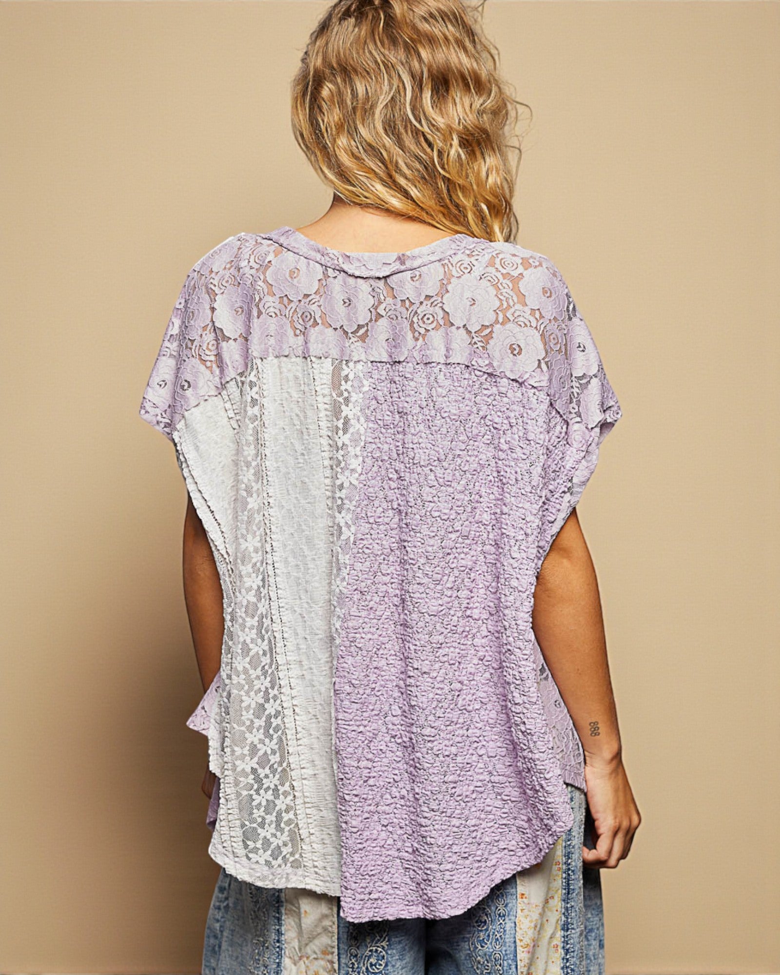 Woman wearing a patterned top with a beige background