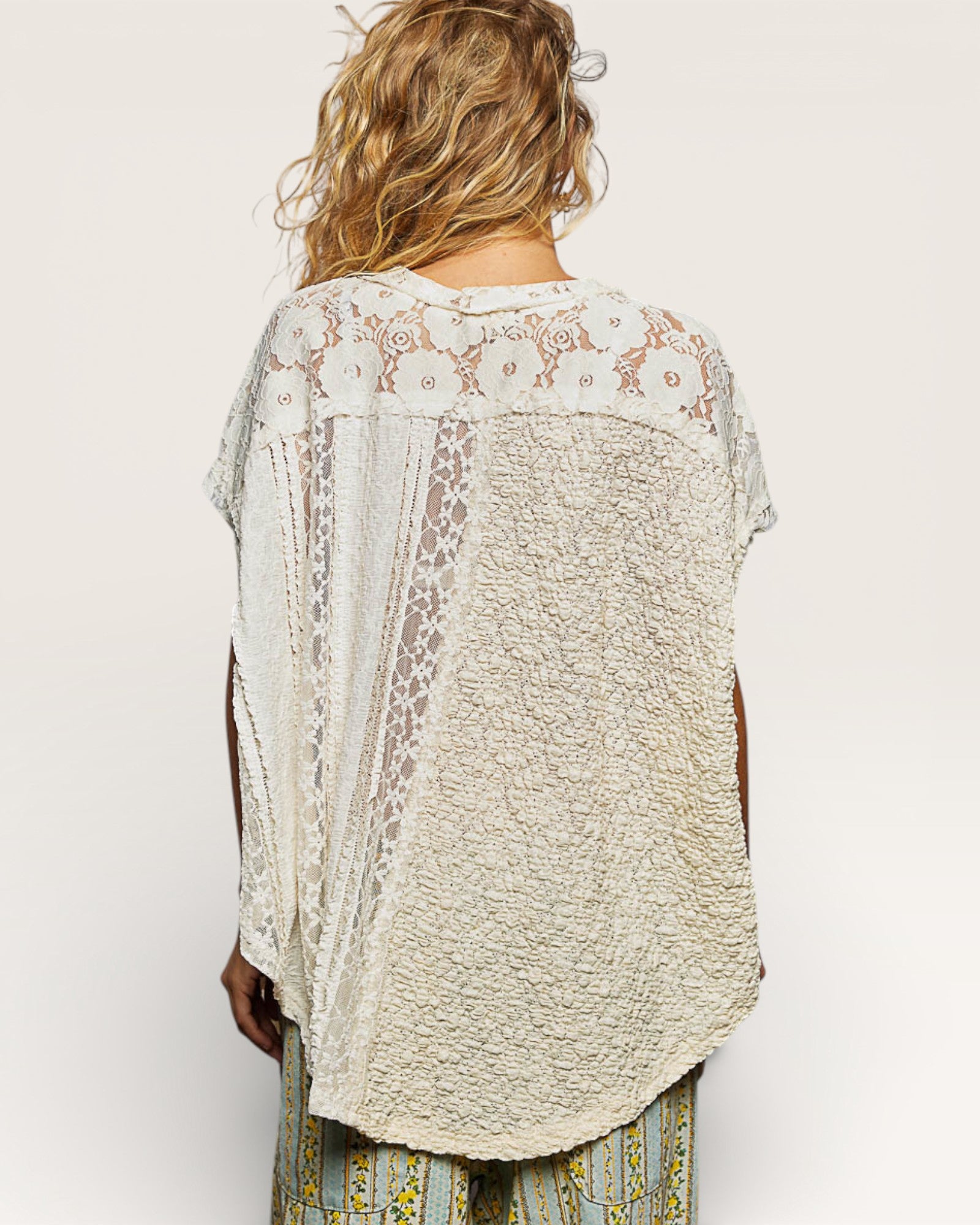 Woman wearing a lace-trimmed beige kimono-style garment on a white background