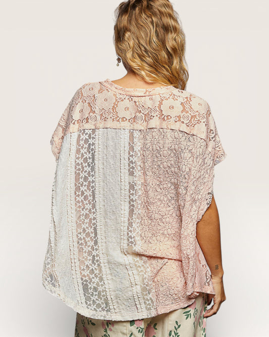 Woman wearing a floral lace top with a neutral background