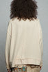 Person wearing a beige textured jacket with a gray background