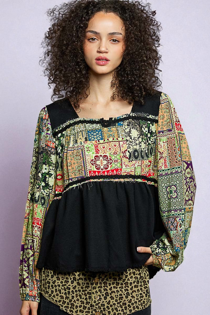 Woman wearing a colorful patchwork top with a black base on a light gray background