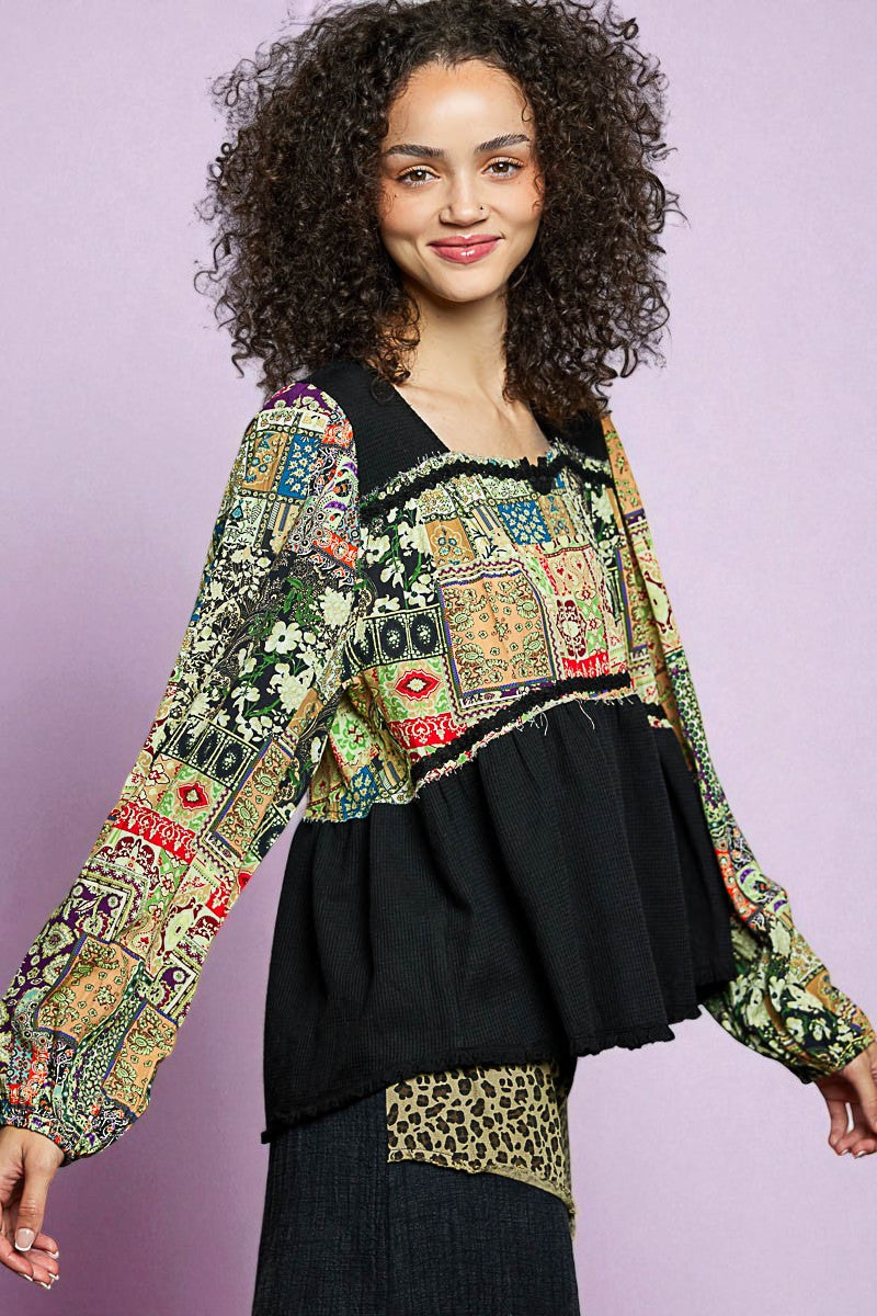 Woman wearing a colorful patterned top with a black skirt against a light purple background