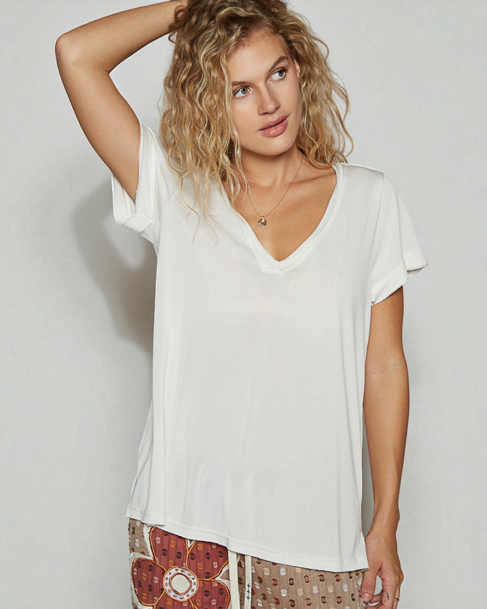 Woman wearing a white t-shirt with a neutral background