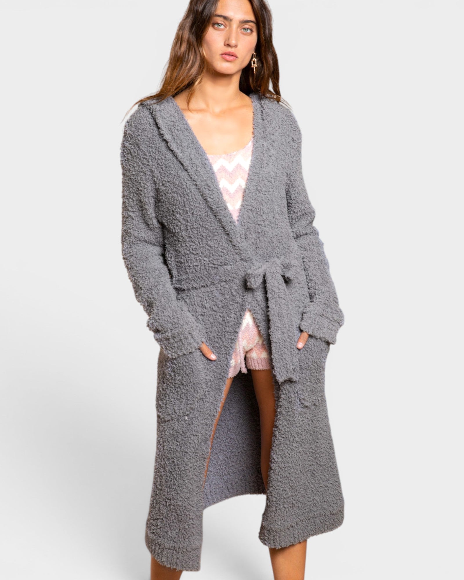 Woman wearing a long gray cardigan on a white background