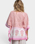 Woman wearing a pink and white patterned outfit on a white background