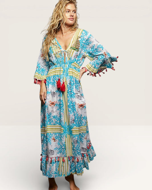 Woman wearing a colorful patterned dress with tassels on a white background