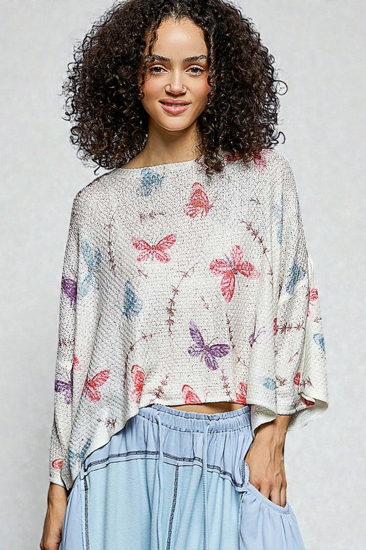 Woman wearing a butterfly-patterned top with a plain background