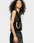 Woman wearing a black sequin top with floral patterns on a white background
