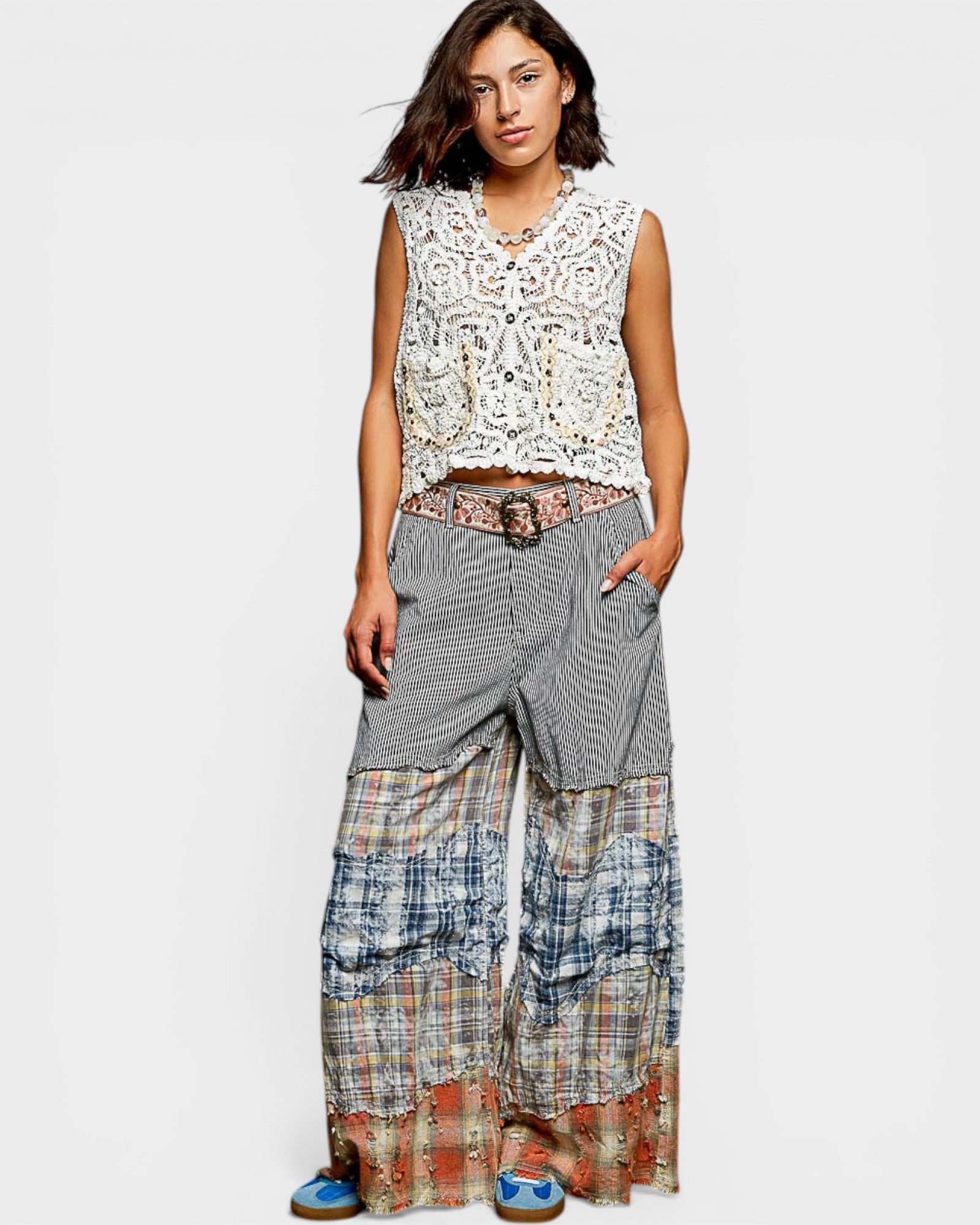 Woman wearing a sleeveless floral top and patterned long skirt on a white background
