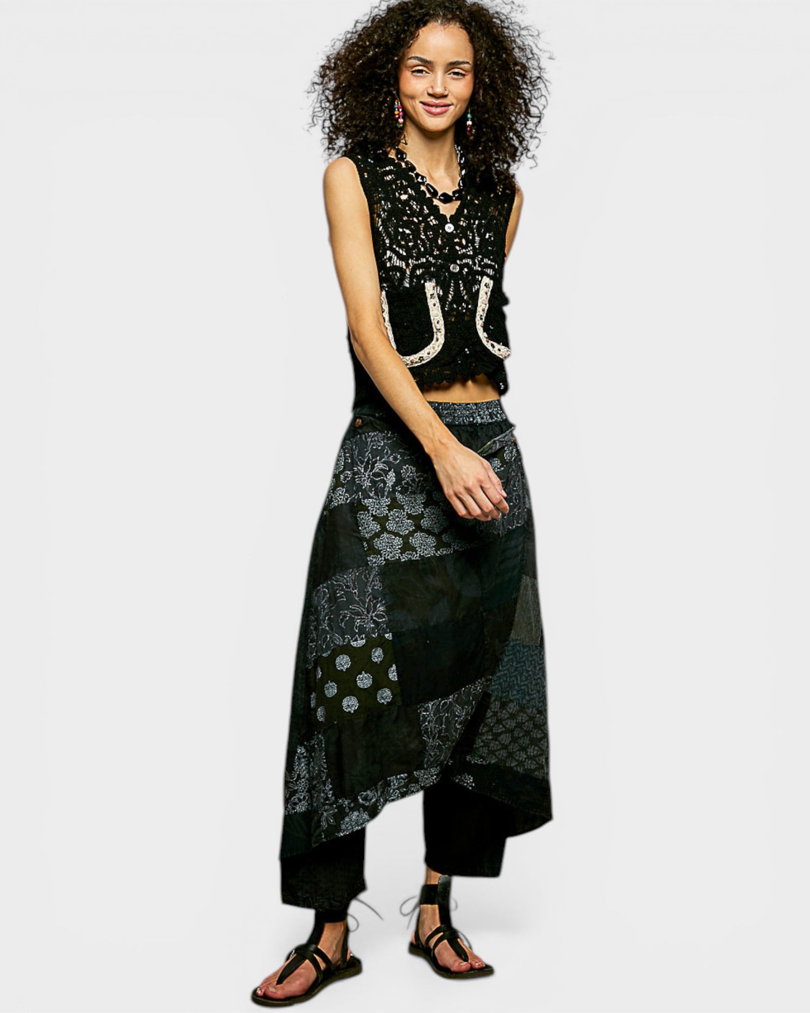 Woman wearing a black patterned outfit on a white background
