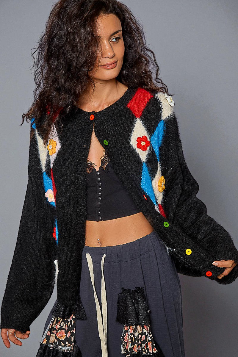 Woman wearing a colorful cardigan with a gray background