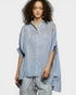 Woman wearing a blue embroidered shirt on a white background