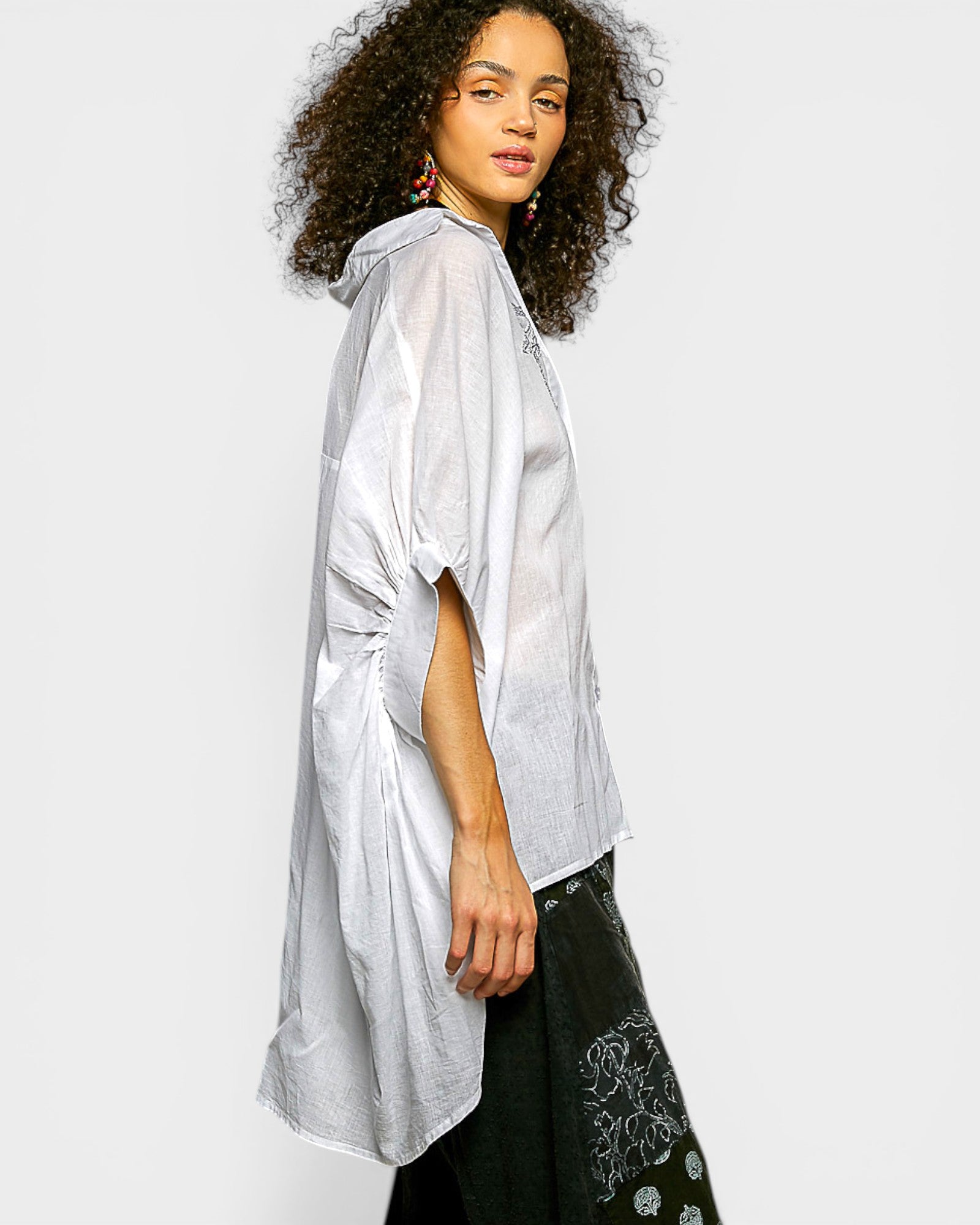 Woman wearing a light gray blouse with a plain background