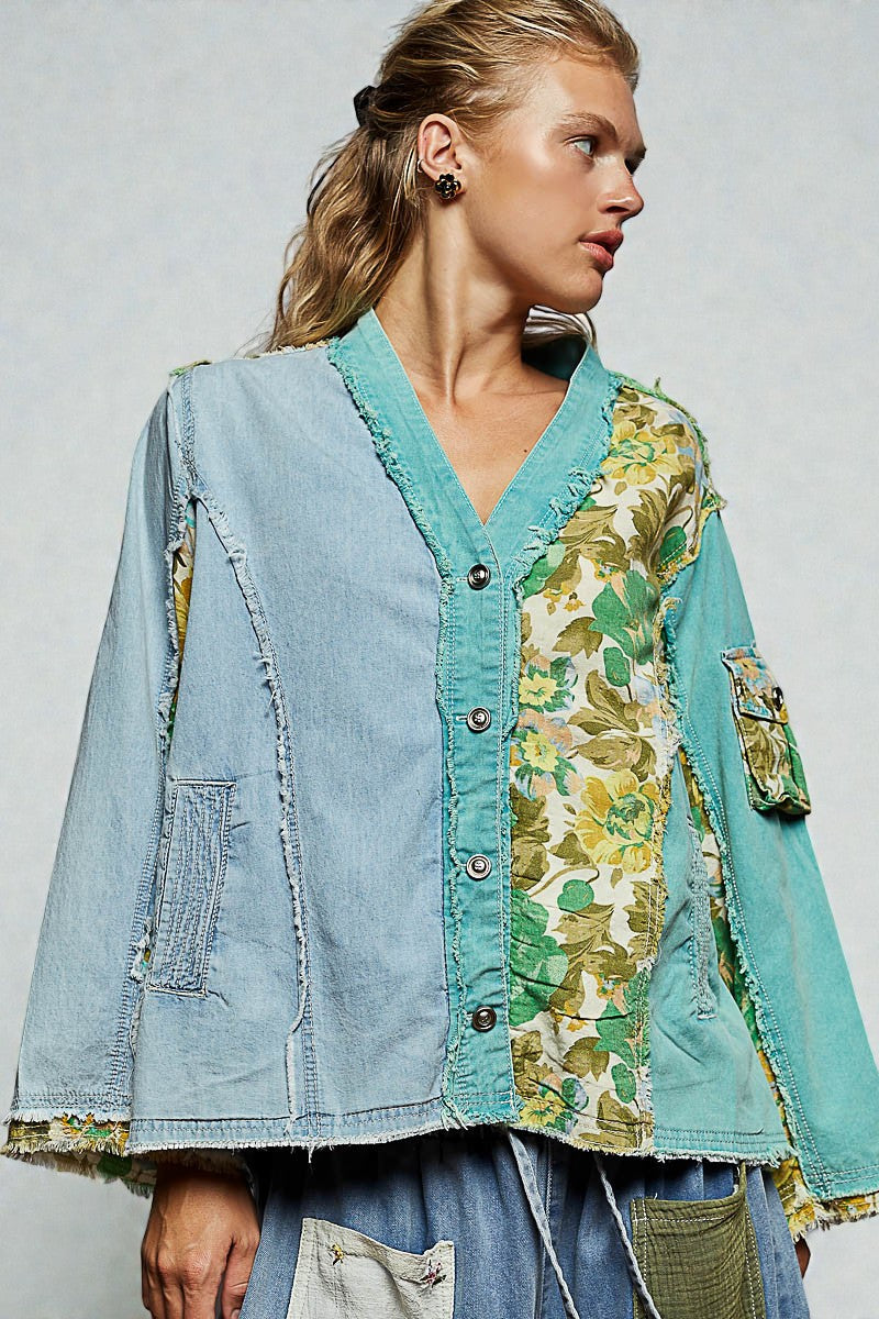 Woman wearing a patchwork jacket with floral and denim patterns on a plain background
