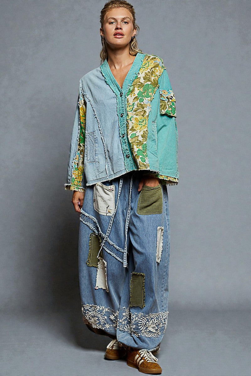 Person wearing a patchwork denim outfit on a gray background