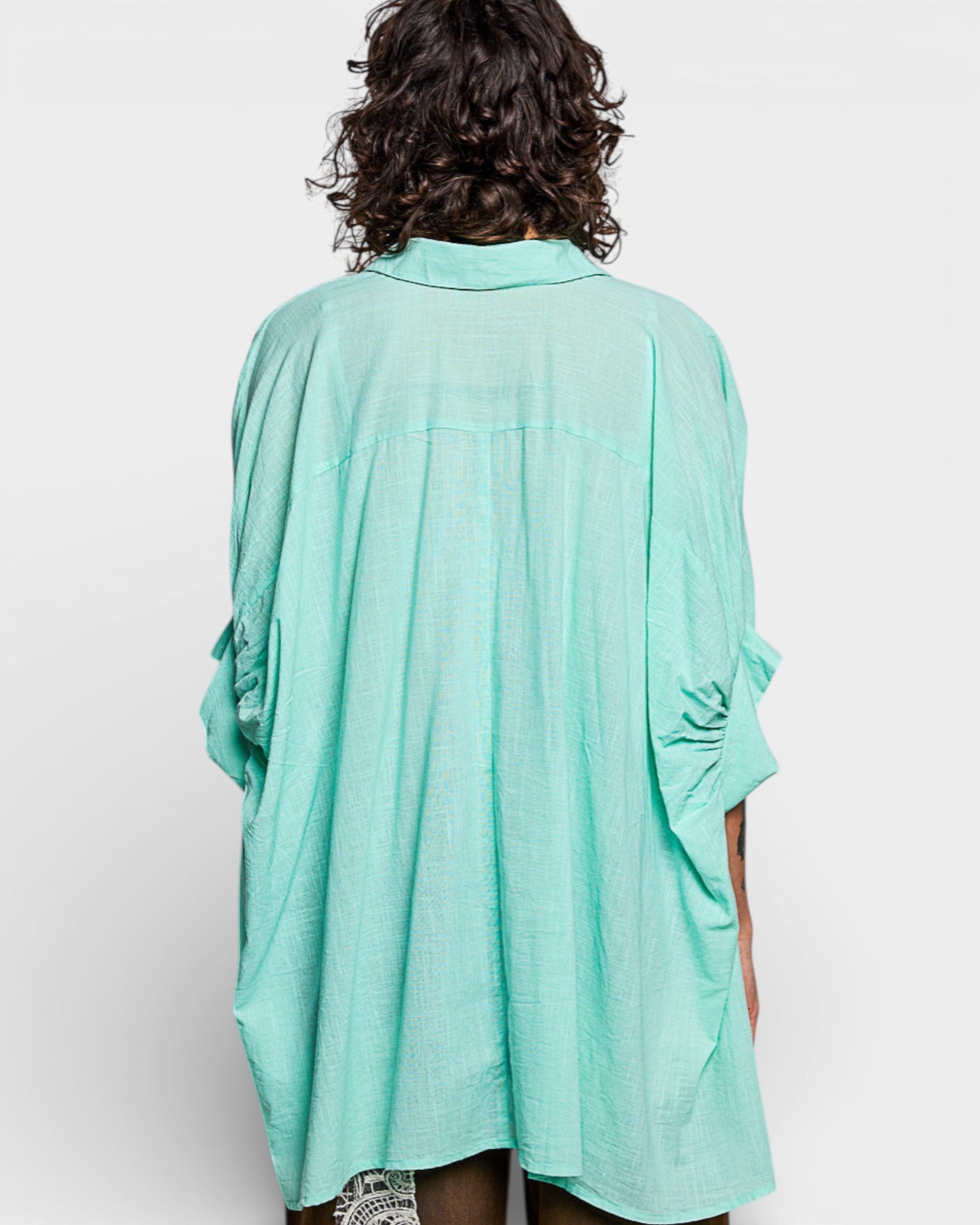 Person wearing a light blue kimono-style garment on a white background