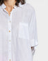 Close-up of a person wearing a light-colored shirt with short sleeves on a white background