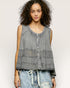 Woman wearing a sleeveless denim top with a plain background