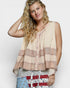 Woman wearing a patterned sleeveless top with a plain background