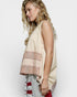 Woman wearing a beige sleeveless top with lace details on a white background